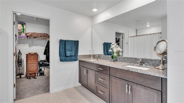 2966 Flying Blackbird Rd, Bartow, FL 33830 - bathroom with double vanity, tile patterned flooring, a walk in closet, a shower with curtain, and baseboards