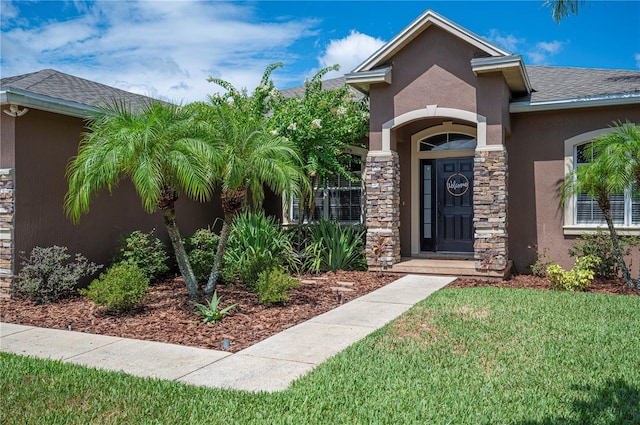 6339 Alamanda Hills Dr, Lakeland, FL 33813 - property entrance with stone siding, stucco siding, and a yard