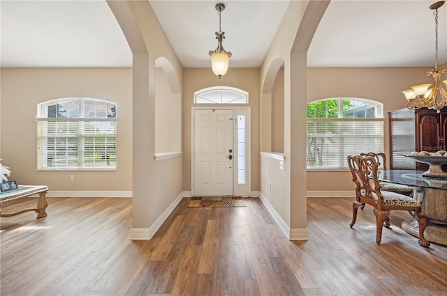6339 Alamanda Hills Dr, Lakeland, FL 33813 - foyer entrance featuring wood finished floors, a chandelier, and arched walkways