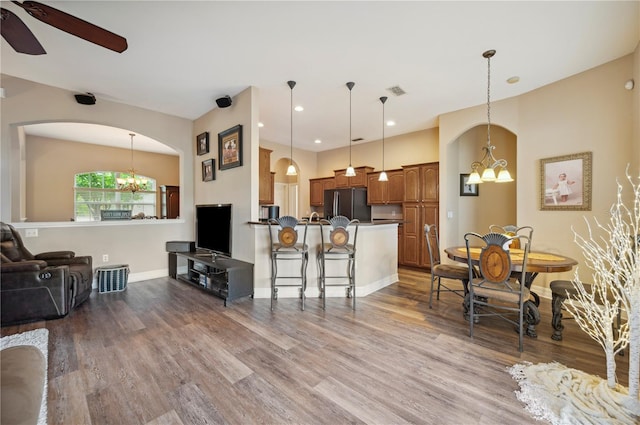 6339 Alamanda Hills Dr, Lakeland, FL 33813 - living room featuring a chandelier, arched walkways, wood finished floors, ceiling fan, and recessed lighting
