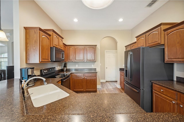 6339 Alamanda Hills Dr, Lakeland, FL 33813 - kitchen featuring black electric range oven, a sink, stainless steel fridge with ice dispenser, light wood finished floors, and arched walkways