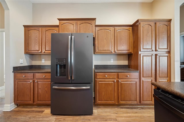 6339 Alamanda Hills Dr, Lakeland, FL 33813 - kitchen with stainless steel fridge with ice dispenser, black dishwasher, dark countertops, and light wood-style floors