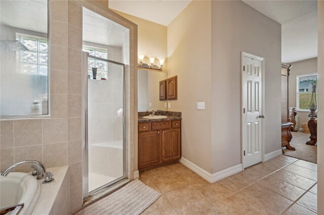 6339 Alamanda Hills Dr, Lakeland, FL 33813 - full bathroom featuring vanity, a bath, a shower stall, tile patterned floors, and baseboards