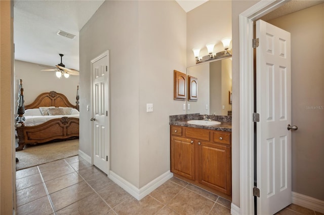 6339 Alamanda Hills Dr, Lakeland, FL 33813 - bathroom with vanity, tile patterned floors, a ceiling fan, baseboards, and ensuite bathroom