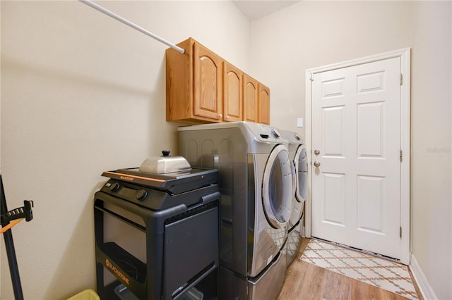 6339 Alamanda Hills Dr, Lakeland, FL 33813 - laundry room featuring washing machine and clothes dryer, light wood-style floors, cabinet space, and baseboards