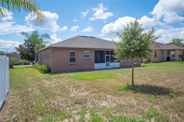 6339 Alamanda Hills Dr, Lakeland, FL 33813 - rear view of house featuring a yard, stucco siding, and a sunroom