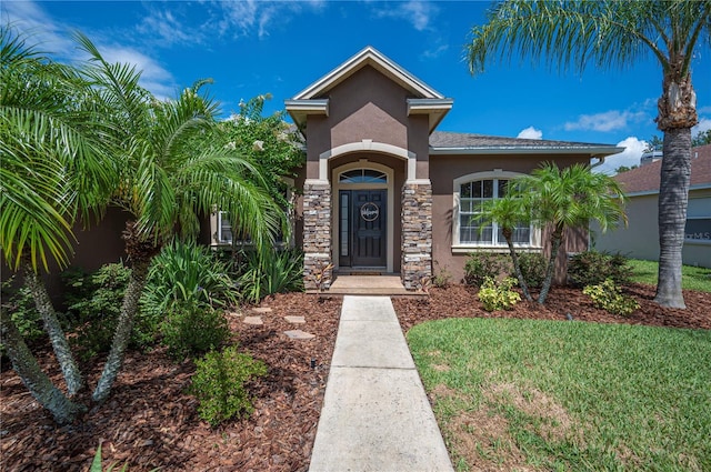 6339 Alamanda Hills Dr, Lakeland, FL 33813 - view of front of house with stucco siding, stone siding, and a front yard