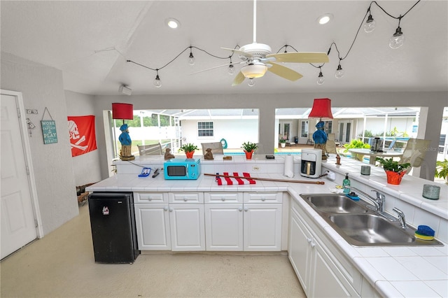 1130 Ewell Rd, Lakeland, FL 33811 - kitchen featuring white microwave, refrigerator, tile counters, a sink, and recessed lighting