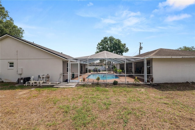 1130 Ewell Rd, Lakeland, FL 33811 - back of property with a lawn, an outdoor pool, glass enclosure, and a patio area
