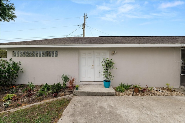 1130 Ewell Rd, Lakeland, FL 33811 - property entrance featuring stucco siding and roof with shingles
