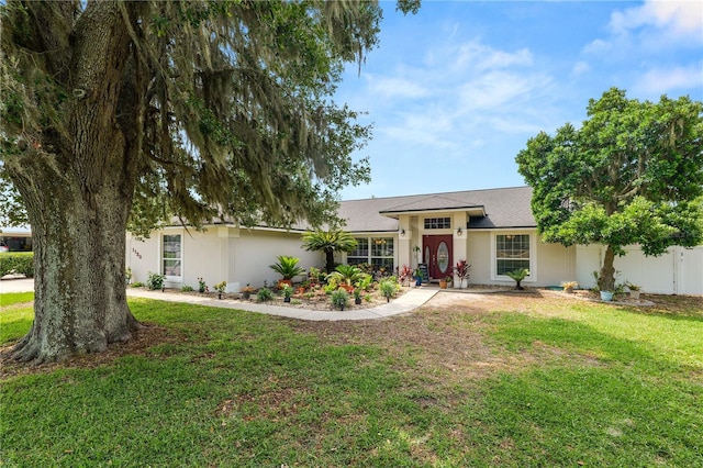 1130 Ewell Rd, Lakeland, FL 33811 - ranch-style house with a front yard, stucco siding, and a shingled roof