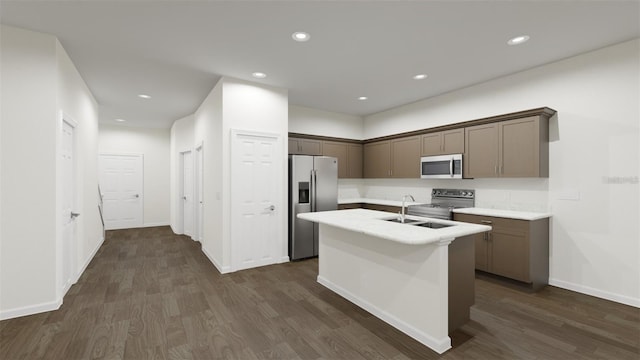 445 Silverbell Trl, Saint Cloud, FL 34771 - kitchen with stainless steel appliances, a sink, dark wood-style flooring, light countertops, and a center island with sink
