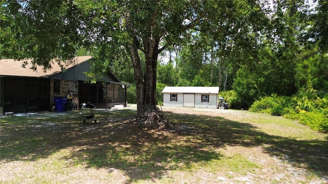 2430 Gresham St, Sebring, FL 33875 - view of grassy yard with a sunroom, an outbuilding, and a fire pit