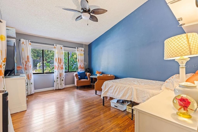13411 Whitby Rd, Hudson, FL 34667 - bedroom featuring wood finished floors, lofted ceiling, a textured ceiling, and a ceiling fan