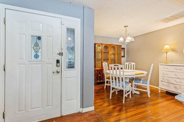 13411 Whitby Rd, Hudson, FL 34667 - foyer entrance with a chandelier, a textured ceiling, wood finished floors, and baseboards