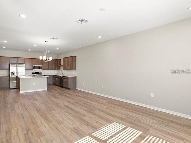 5771 Freshwater Canyon Dr, Saint Cloud, FL 34771 - kitchen featuring appliances with stainless steel finishes, a chandelier, open floor plan, light countertops, and baseboards