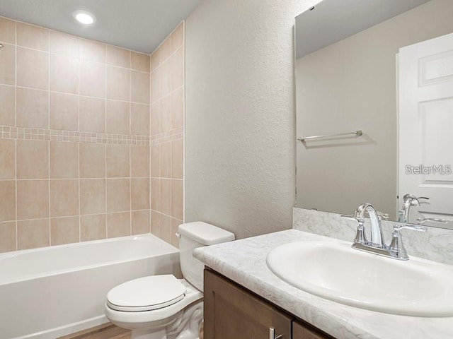 5771 Freshwater Canyon Dr, Saint Cloud, FL 34771 - bathroom featuring toilet, vanity, a textured wall, tub / shower combination, and recessed lighting