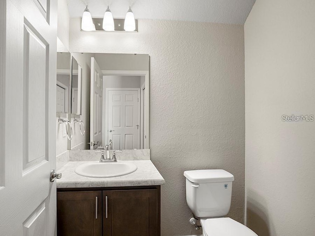 5771 Freshwater Canyon Dr, Saint Cloud, FL 34771 - bathroom with toilet, vanity, and a textured wall
