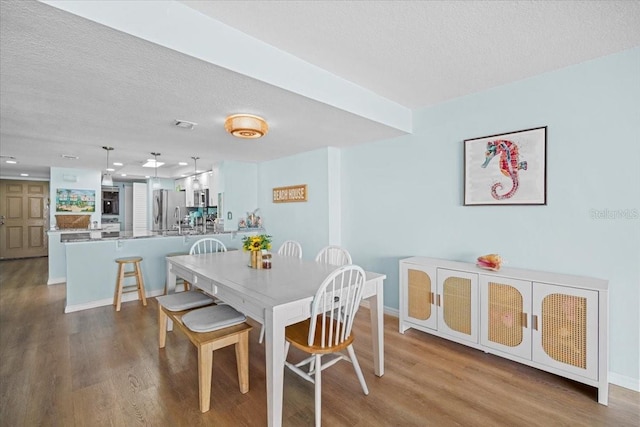 830 N Atlantic Ave Unit B502, Cocoa Beach, FL 32931 - dining area featuring wood finished floors, a textured ceiling, and baseboards