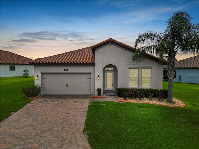 4125 Prima Lago Cir, Lakeland, FL 33810 - mediterranean / spanish-style house with a garage, decorative driveway, stucco siding, and a front yard