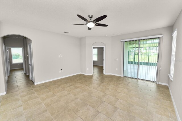 4125 Prima Lago Cir, Lakeland, FL 33810 - unfurnished room featuring arched walkways, a ceiling fan, healthy amount of natural light, and baseboards
