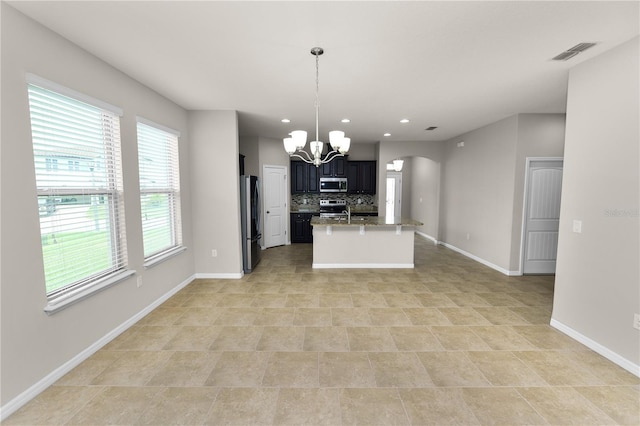4125 Prima Lago Cir, Lakeland, FL 33810 - kitchen featuring stainless steel appliances, a chandelier, arched walkways, baseboards, and backsplash