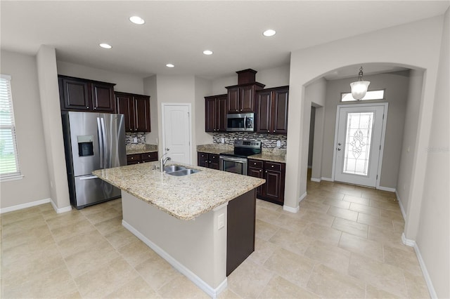 4125 Prima Lago Cir, Lakeland, FL 33810 - kitchen featuring stainless steel appliances, a sink, arched walkways, backsplash, and dark brown cabinetry