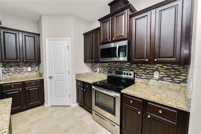 4125 Prima Lago Cir, Lakeland, FL 33810 - kitchen featuring stainless steel appliances, backsplash, dark brown cabinets, and light stone countertops