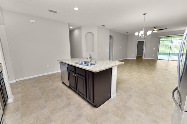 4125 Prima Lago Cir, Lakeland, FL 33810 - kitchen featuring a sink, stainless steel appliances, arched walkways, baseboards, and a kitchen island with sink