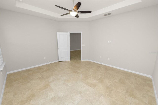 4125 Prima Lago Cir, Lakeland, FL 33810 - unfurnished room featuring a tray ceiling, a ceiling fan, and baseboards