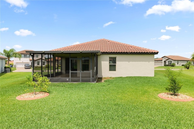 4125 Prima Lago Cir, Lakeland, FL 33810 - rear view of house featuring a sunroom, a yard, stucco siding, and a tiled roof
