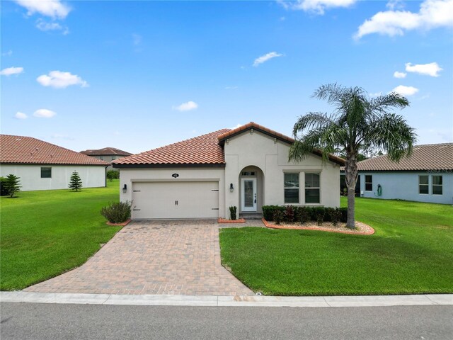 4125 Prima Lago Cir, Lakeland, FL 33810 - mediterranean / spanish home featuring stucco siding, an attached garage, decorative driveway, and a front yard