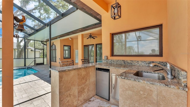 5370 Boxtree Ct, Dade City, FL 33523 - view of patio featuring exterior kitchen, a sink, an outdoor pool, a lanai, and ceiling fan