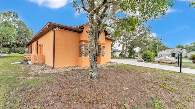 5370 Boxtree Ct, Dade City, FL 33523 - view of side of home with stucco siding and a yard