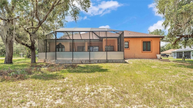 5370 Boxtree Ct, Dade City, FL 33523 - back of house with a yard, stucco siding, and glass enclosure