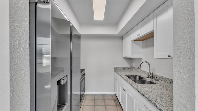 1017 Fleming Ave, Lakeland, FL 33815 - kitchen featuring a sink, stainless steel fridge with ice dispenser, white cabinetry, light stone counters, and a textured wall
