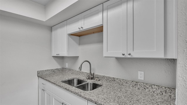 1017 Fleming Ave, Lakeland, FL 33815 - kitchen featuring a sink, white cabinetry, light stone countertops, and a textured wall