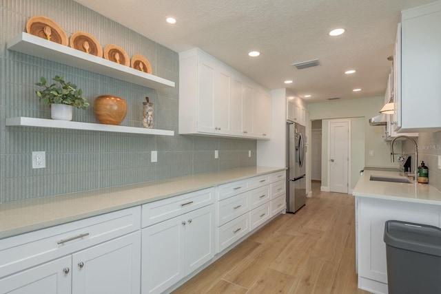 3626 Corsair Ct, New Port Richey, FL 34652 - kitchen with open shelves, stainless steel refrigerator with ice dispenser, a sink, white cabinetry, and recessed lighting