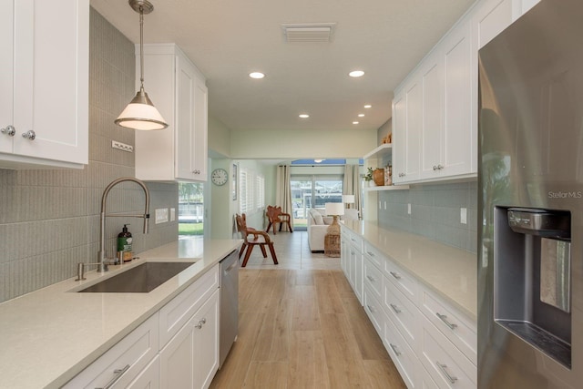 3626 Corsair Ct, New Port Richey, FL 34652 - kitchen with stainless steel appliances, a sink, recessed lighting, tasteful backsplash, and white cabinets