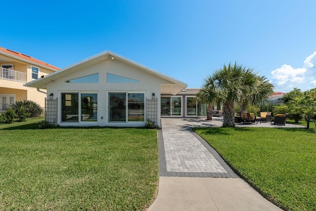 3626 Corsair Ct, New Port Richey, FL 34652 - rear view of house featuring a lawn, stucco siding, and a patio area