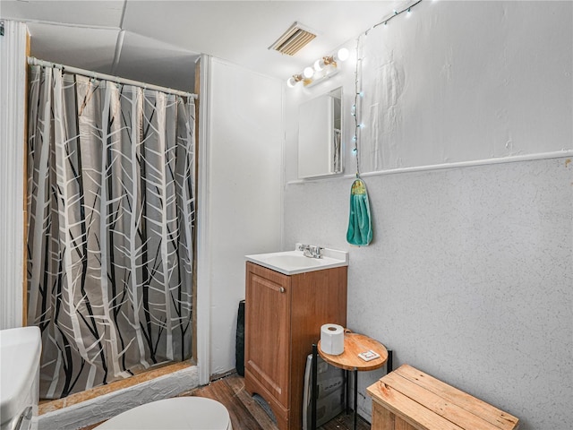 2120 Dille St, Lakeland, FL 33815 - full bathroom featuring vanity, toilet, a shower with shower curtain, and wood finished floors