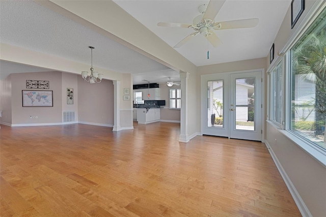 3487 Highland Fairways Blvd, Lakeland, FL 33810 - unfurnished living room featuring ceiling fan, a chandelier, light wood-style floors, and baseboards