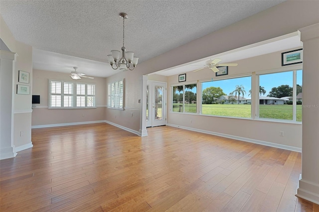 3487 Highland Fairways Blvd, Lakeland, FL 33810 - unfurnished dining area with a chandelier, a textured ceiling, a ceiling fan, light wood-style floors, and baseboards