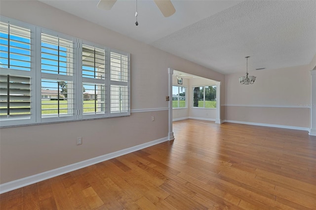 3487 Highland Fairways Blvd, Lakeland, FL 33810 - unfurnished room with a ceiling fan, a chandelier, wood finished floors, baseboards, and a textured ceiling