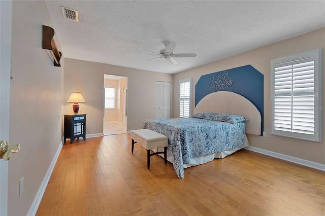 3487 Highland Fairways Blvd, Lakeland, FL 33810 - bedroom with multiple windows, wood finished floors, baseboards, and a textured ceiling