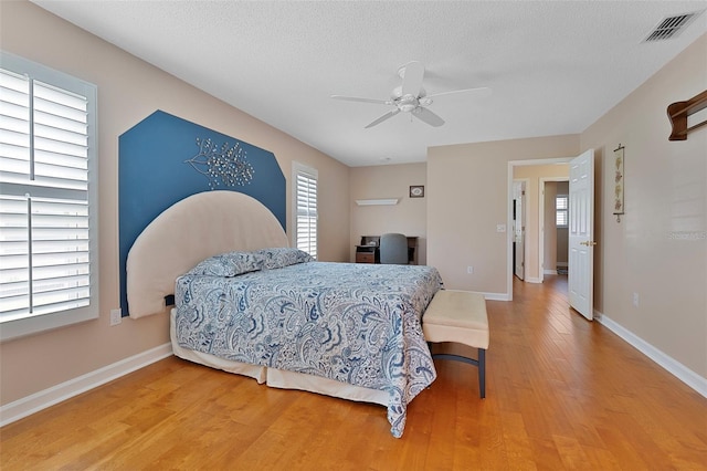 3487 Highland Fairways Blvd, Lakeland, FL 33810 - bedroom with light wood-style flooring, multiple windows, baseboards, and a textured ceiling