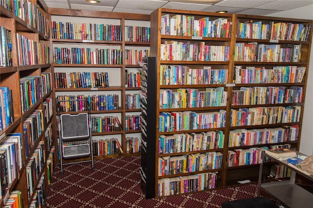 3487 Highland Fairways Blvd, Lakeland, FL 33810 - sitting room with wall of books, a drop ceiling, and carpet flooring