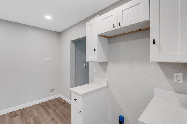 3601 Ave R NW, Winter Haven, FL 33881 - kitchen with light wood-type flooring, white cabinetry, light countertops, baseboards, and recessed lighting