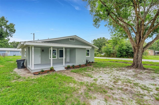 3601 Ave R NW, Winter Haven, FL 33881 - view of front facade with covered porch, a front lawn, and stucco siding