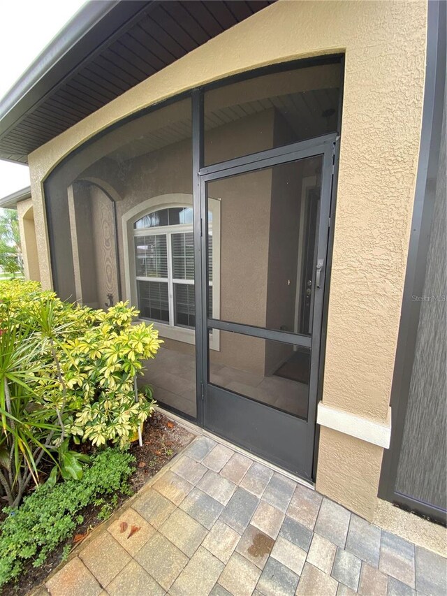 1167 Motorcoach Dr, Polk City, FL 33868 - view of exterior entry featuring stucco siding